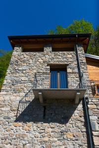 内索Tra Lago e Montagna Baita la Morena的带阳台的石质建筑窗户