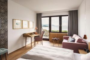 特劳恩基兴Das Traunsee - Das Hotel zum See的配有一张床和一张书桌的酒店客房