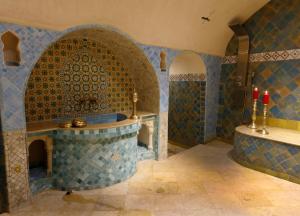 舍夫沙万里亚德彻利法旅馆的浴室配有浴缸和带红色蜡烛的盥洗池。