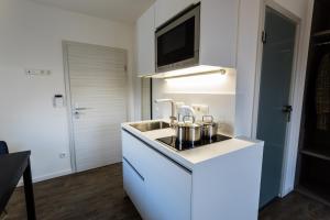 拜罗伊特国王大道公寓的白色的厨房配有水槽和微波炉