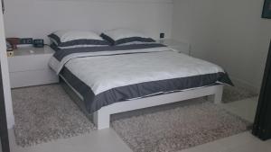 华沙Okolnik Apartment的卧室配有一张带白色和黑色棉被的床