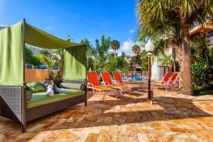 劳德代尔堡海滩俱乐部酒店的一个带沙发和椅子的庭院,毗邻一个游泳池