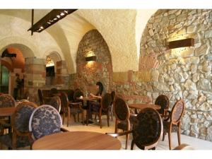 巴亚马雷迪亚芬酒店的一间带桌椅和石墙的餐厅