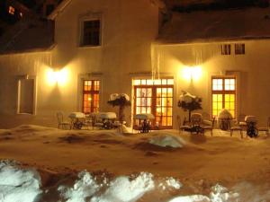 伊诺弗罗茨瓦夫威拉维多利亚旅馆的一座在晚上下雪的建筑,里面摆放着桌椅