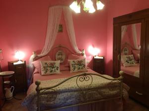阿夏诺阿古里图里斯莫Il帕拉迪索酒店的一间卧室配有两张粉红色墙壁的床