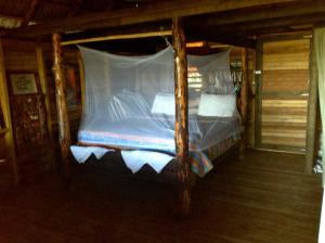 TubaguaEcolodge Tubagua Puerto Plata的小屋内一张带天蓬的床