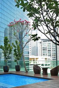 吉隆坡吉隆坡翠绿山酒店的一座有树木和建筑的建筑中的游泳池