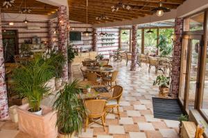 豪伊杜索博斯洛普拉坦花园酒店的一间设有桌椅的餐厅,种植了植物