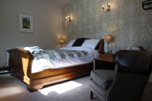 ChinleyThe Lamb Inn的一间卧室配有一张大床和一把椅子