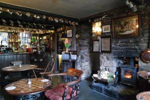 ChinleyThe Lamb Inn的酒吧设有桌椅和壁炉