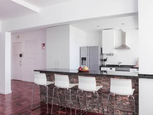卡尔卡维洛斯casaRene的厨房配有白色橱柜和带白色椅子的台面
