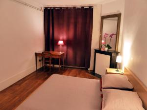 凡尔赛莱斯卡瑞斯酒店的一间配有沙发、一张桌子和一面镜子的客房