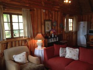 海姆维尔Willowbrooke Cottage的客厅配有红色的沙发和两把椅子
