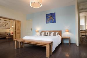 圣艾米隆Demeure des Girondins的一间卧室设有一张大床和一张木凳