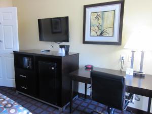 泰勒泰勒行政套房酒店的酒店客房配有书桌和电视。