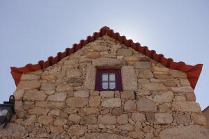 塞亚Casas da Fonte - Serra da Estrela的一座建筑,在石墙里设有窗户