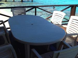 阿瓦托鲁Pension Turiroa " Chez Olga"的蓝色的桌子和椅子,背景是大海