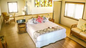 拉罗汤加穆里海滩度假酒店的一间卧室配有一张床、一张沙发和一把椅子