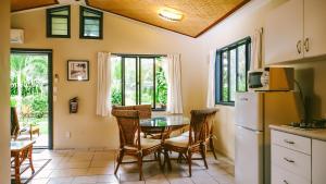 拉罗汤加穆里海滩度假酒店的厨房以及带桌子和冰箱的用餐室