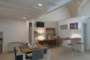 马利耶Corte Campanile Boutique B&B的厨房以及带桌椅的用餐室。