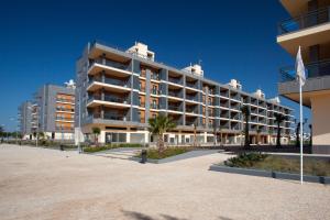 奥良瑞尔玛丽娜滨海酒店的海滩上一座带国旗的大型公寓楼