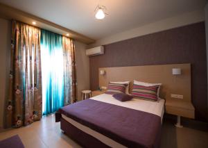 阿莫利亚尼岛Aloe Apartments Ammouliani的一间卧室设有一张大床和一个窗户。