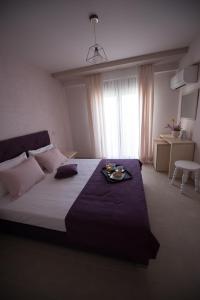 阿莫利亚尼岛Aloe Apartments Ammouliani的一间卧室配有一张床,上面放着一个食物托盘