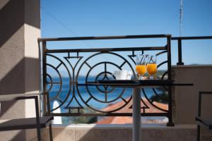 阿莫利亚尼岛Aloe Apartments Ammouliani的阳台上的桌子,上面有2杯和眼镜