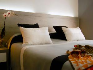 弗拉斯卡蒂Residence Frascati的一间卧室配有两张带白色和黑色枕头的床