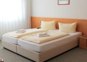 科尔平塞乌瑟多姆岛维多利亚别墅公寓的一张大床,上面有两个白色枕头