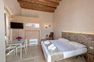 莫迪卡Stacci Rural Resort的一间卧室配有一张床、一张桌子和一台电视