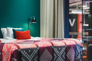 斯德哥尔摩柏酒店的一间卧室配有一张带红白毯子的床