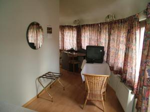 哈勒艾斯布特酒店的客房设有一张桌子、一台电视和一张书桌