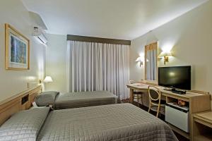 库里提巴特雷维电子商务酒店的酒店客房设有两张床和一张书桌及电视