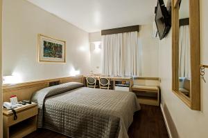库里提巴特雷维电子商务酒店的酒店客房,配有一张床和两把椅子