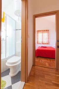 图彻皮Villa Lora的一间带卫生间的浴室和一张红色的床