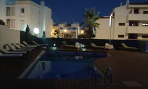 阿尔布费拉阿尔布费拉KR酒店的一座游泳池,在晚上在建筑物前