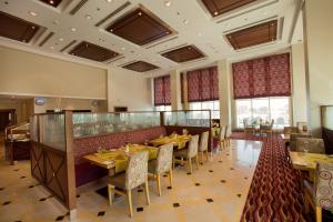 科威特Copthorne Al Jahra Hotel & Resort的一间在房间内配有桌椅的餐厅