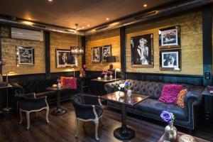 阿姆斯特丹塞巴斯蒂安斯酒店的酒吧设有皮沙发、桌子和墙上的照片