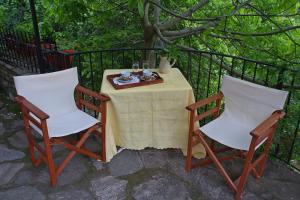 普里诺斯Katoikia me ta Pitharia的围栏旁的一张桌子和两把椅子