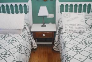 埃斯皮纳马Hostal Puente Deva的一间卧室配有两张床和一张带台灯的桌子