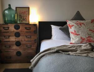 小谷村Cortina Apartment的一间卧室配有梳妆台和一张带毯子的床