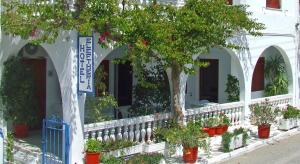 帕罗奇亚埃雷菲塞里亚酒店的白色的建筑,有树木和盆栽植物