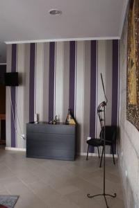 阿利若Alojamento Galerias Nascentes的客厅拥有紫色和白色条纹墙和椅子