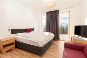 滨湖采尔Schmiedhof Alm的一间卧室设有一张大床和一个大窗户
