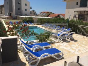 巴什卡沃达多里基尼多沃里酒店的一组蓝色的躺椅,位于游泳池旁