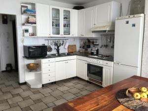 里耶卡Rijeka Fiorino Apartment的厨房配有白色橱柜和木桌