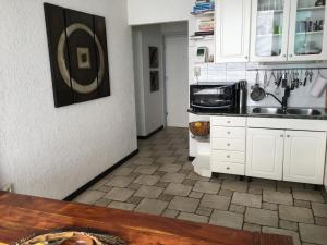 里耶卡Rijeka Fiorino Apartment的厨房配有白色橱柜和瓷砖地板。
