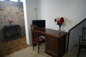 圣米格尔德阿沃纳阿基纳4号度假屋的一张桌子,上面有一台电脑和花瓶