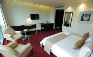 布拉柴维尔GHS酒店的酒店客房配有一张床、一把椅子和一张书桌